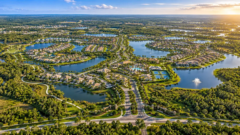 Aerial view of a Naples area master planned village showing neighborhoods, lakes and green corridors